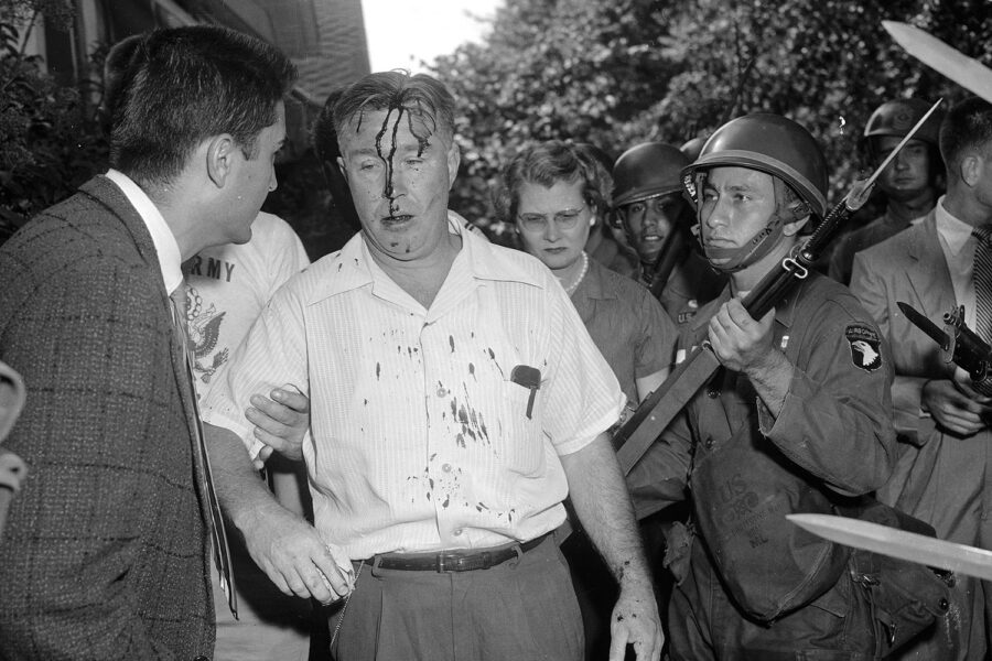 The 101st Airborne explaining school desegregation to a Little Rock protester.